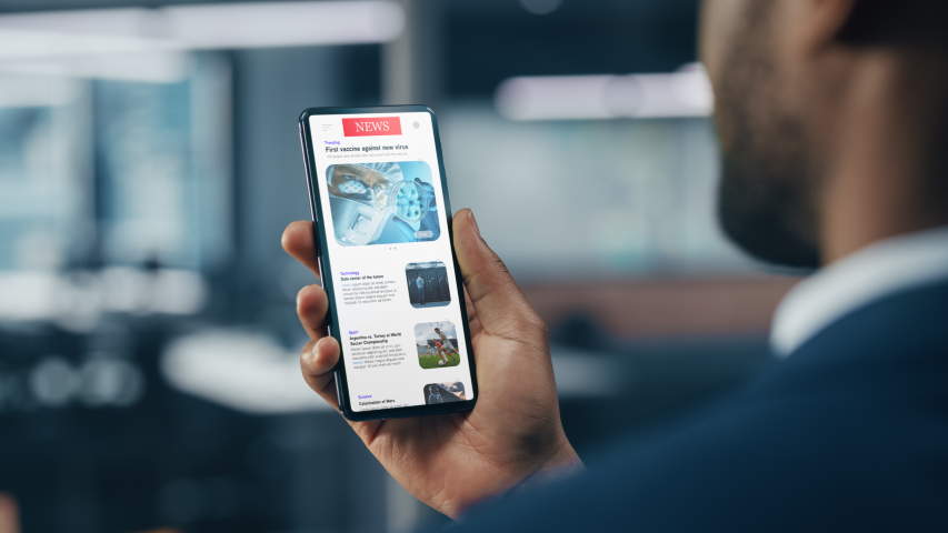 Businessman Using Smartphone for Checking Latest News in Office