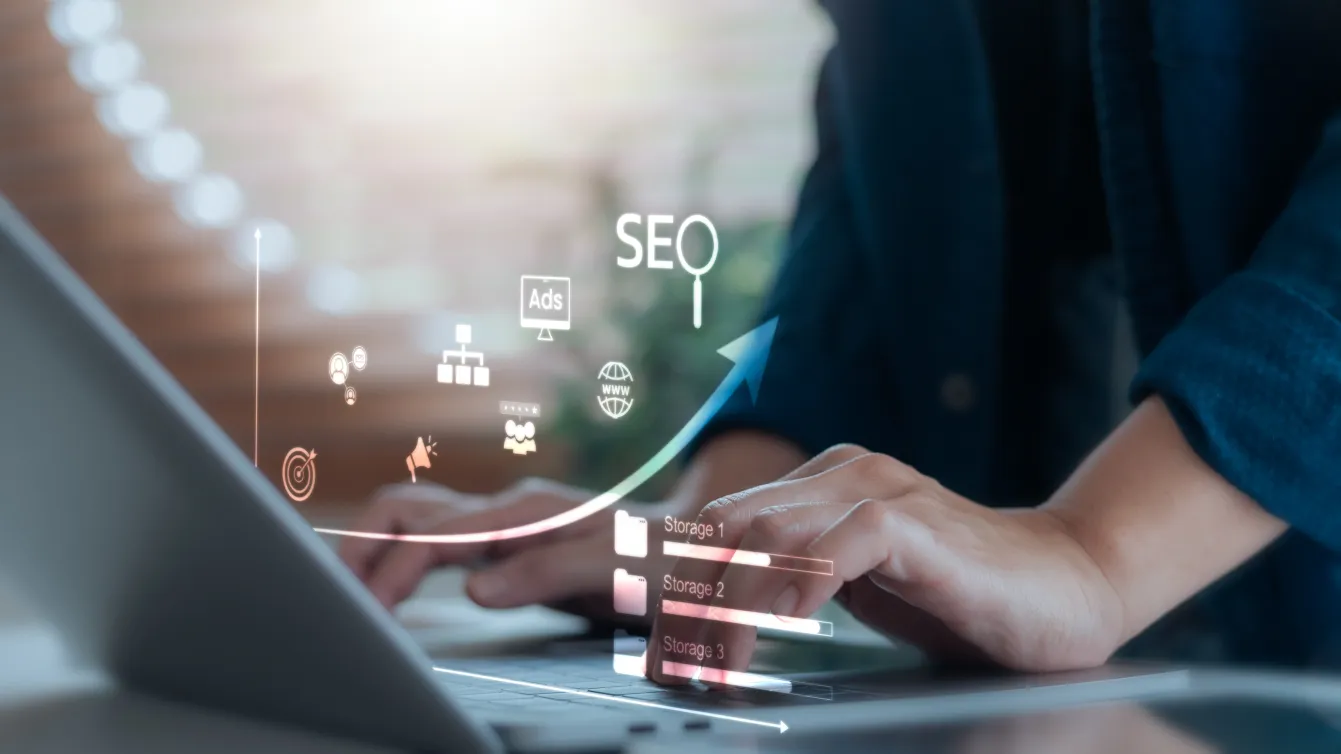 Hands typing on a laptop with SEO icons representing SEO site indexing and website optimization