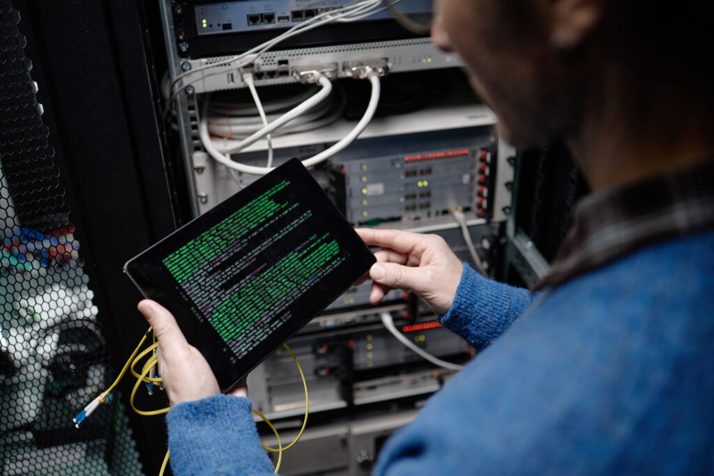 Technician running network diagnostics on a tablet in a server rack