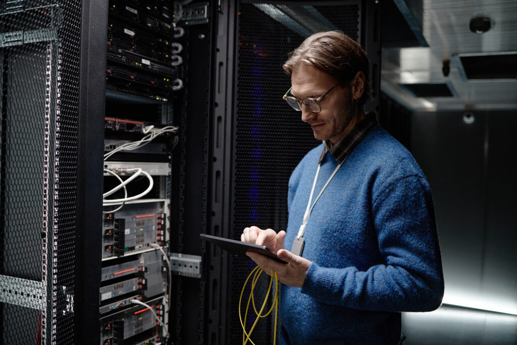 IT technician reviewing server infrastructure during an assessment, signs of outgrown IT
